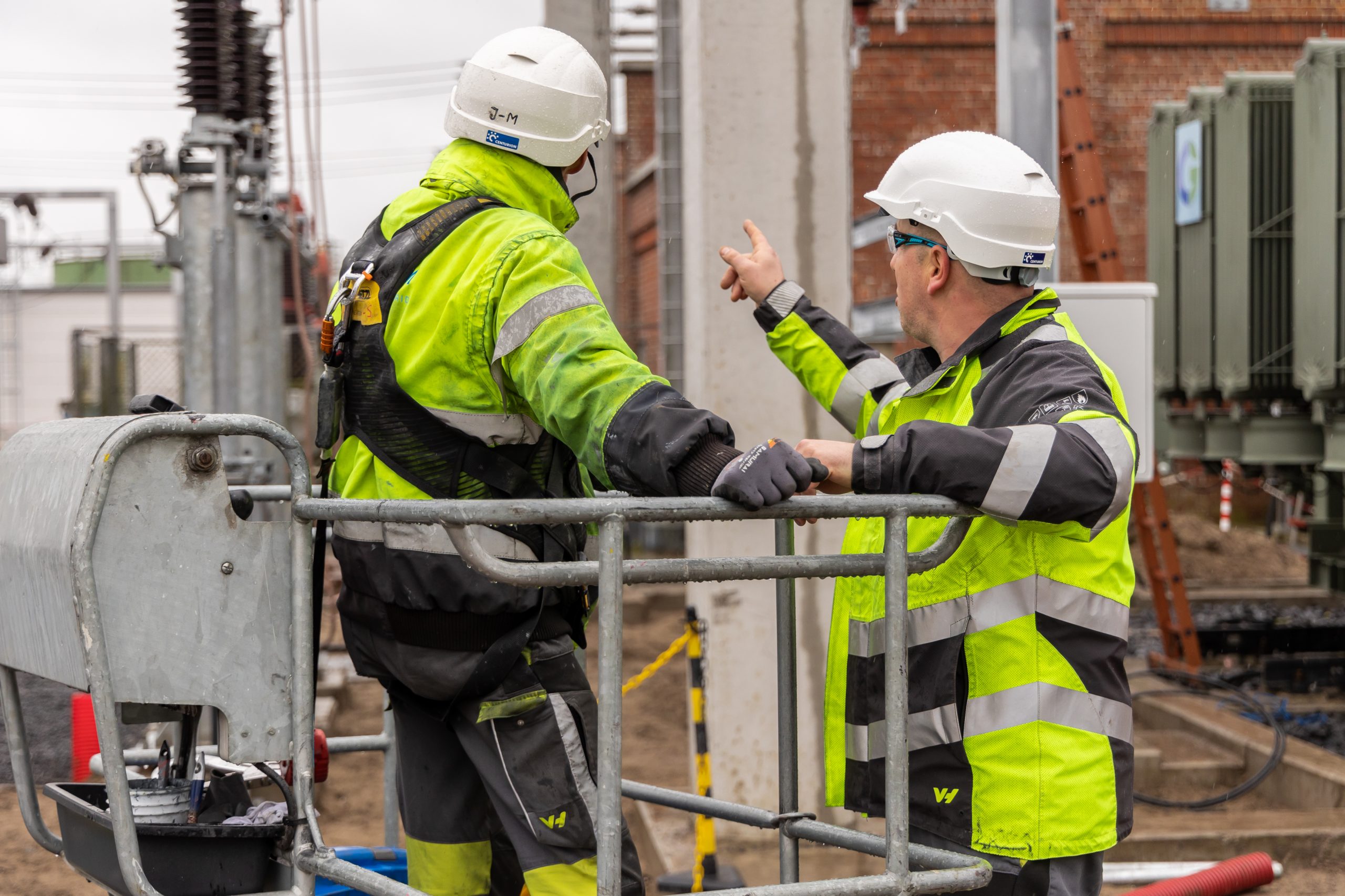 Two Omexom employees talking in front of the substation